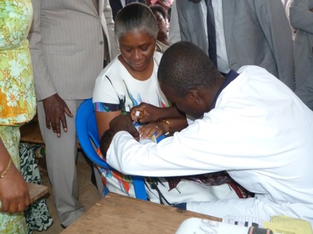 Dr Lucile Imboua, Représentant de l'OMS au Togo aidant à la vaccination d'un enfant.