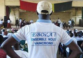 Man wearing tshirt with text "together we shall overcome Ebola" at a social mobilization event in Guinea WHO /Cristiana Salvi
