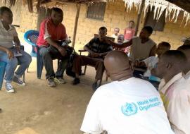 L’équipe conjointe des experts MSP-OMS s’entretenant avec un chef de groupement et des membres de sa communauté sur les mesures d’hygiène individuelle et collective à appliquer pendant cette période de l’épidémie de choléra dans un village situé le long du fleuve Congo, près de Mbandaka, Province de l’Equateur