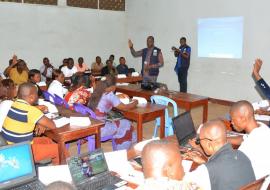Le Dr Jean-Paul Ngandu, consultant de l'OMS spécialiste en prévention et contrôle de l'infection en pleine discussion avec les prestataires de la zone de santé de Bolenge dans une des salles du Centre de formation des cadres de l'EPSP Mbandaka . OMS/Eugene Kabambi Le Dr Jean-Paul Ngandu, consultant de l'OMS spécialiste en prévention et contrôle de l'infection en pleine discussion avec les prestataires de la zone de santé de Bolenge dans une des salles du Centre de formation des cadres de l'EPSP Mbandaka . OMS/Eugene Kabambi