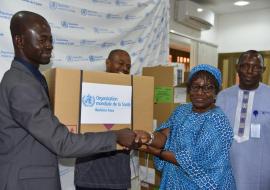 Directeur de Cabinet du Ministère de Santé, Monsieur Emmanuel Sorgho, is receiving a kit from the Burkina Faso WR Dr. Alimata J. Diarra-Nama.