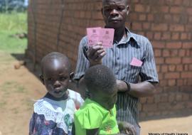Proud father shows off his daughter's immunization cards 