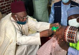 Shehu of Borno administers malaria chemoprevention drug to his grandson.