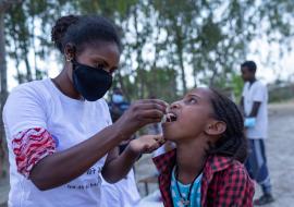 Selamawit administers oral cholera vaccine to a young girl at Yekatit 23 IDP camp in Mekelle