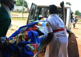 Nurses help to put an expectant mother into the ambulance upon referral to the next level health facility. Ambulance services have made it possible for such timely referrals.