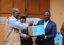 Le Coordonnateur Résident du SNU remettant un lot de médicaments au Ministre de l'intérieur et de la Sécurité Publique pour renforcer la prise en charge sanitaire des personnes déplacées dans le Nord du Bénin