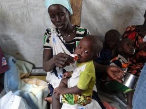 Femme donnant une aide nutritionnelle à son enfant PlumpyNut au Soudan du Sud, ancien État Unity