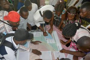 Les participants à l'atelier  de cartographie participative  en pleine discussion sur les mouvements de la population à Mbandaka aux points de passage et rassemblement importants. OMS/Eugene Kabambi 