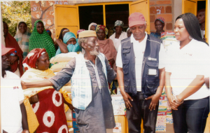 Centre (from left to right) : In light blue jacket, Baba Idris Haliru, Dr Andrew Mbewe (WHO) and Mrs Abigael Molme (Molme Foundation). Behind: Some of the beneficiaries of the intervention at Goza IDP camp. 