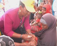 Dr Iheoma Onuekwusi, WHO Kenya EPI Lead, vaccinates a child at the polio launch
