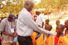 A senior Public Health Officer administering medicine to school children