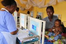 A nurse providing care to a sick child at the paediatric unit at the Kenema District Government Hospital.