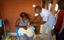 James Osu administering oral polio vacccine  to a neonate in the camp