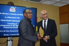 Dr Hon K. K. Jagutpal, Minister of Health and Wellness handing over a shield to Dr. L. Musango to mark the close collaboration and the support received from WHO to contain COVID-19 in Mauritius