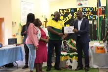Mr. Jeremia Shikulo, Omaheke Region Health Director handing over a certificate to one of the Silver Health Promoting Schools 