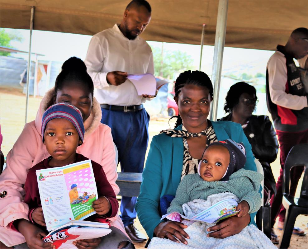 Two mothers received leaflets on nutrition in their local language during a special health outreach point 
