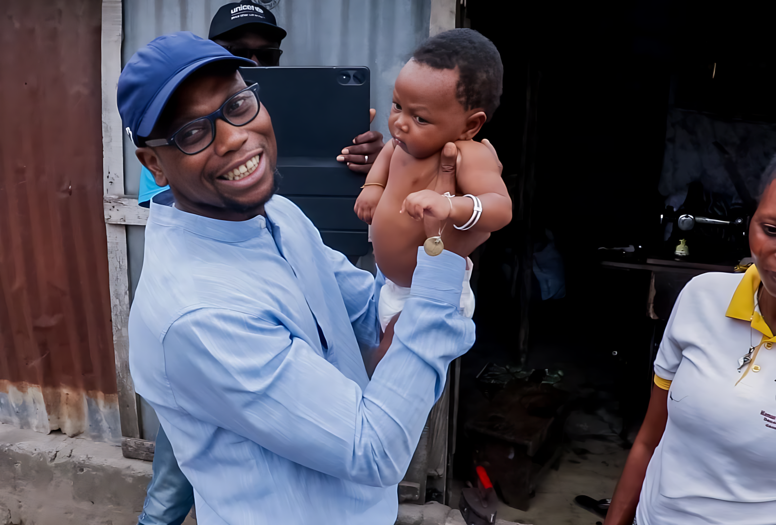 Le Ministre de la Santé Prof Benjamin Hounkpatin tenant un  enfant cible vacciné contre la Polio 