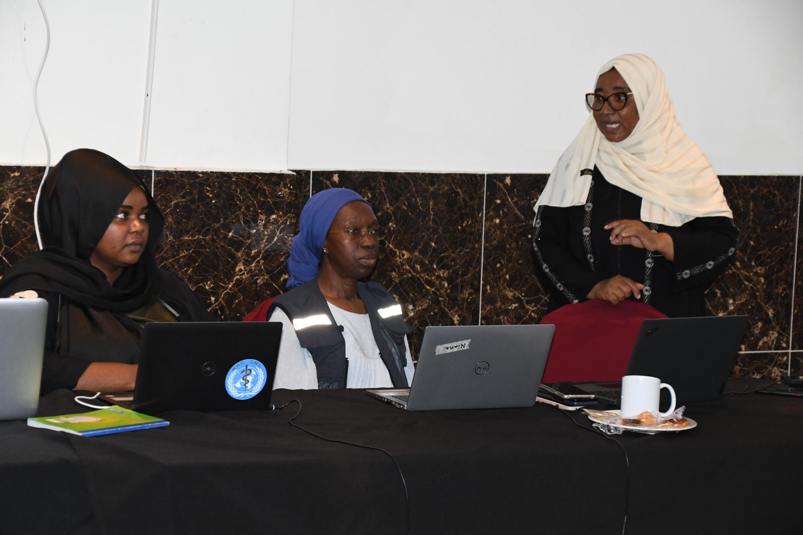 Deux collègues de l'OMS à gauche, avec une collaboratrice de la direction de la santé familiale