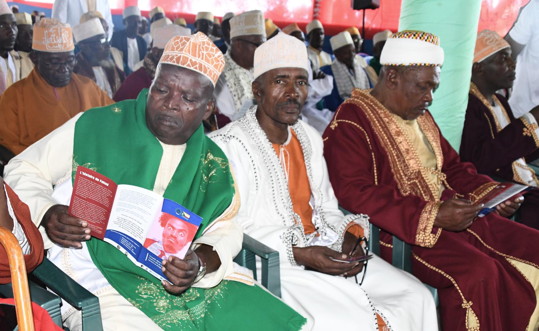 Des notables de Tsinimoichongo, à Ngazidja, lisent les brochures distriuées à l'occasion de la célébration du 26 juin 2025