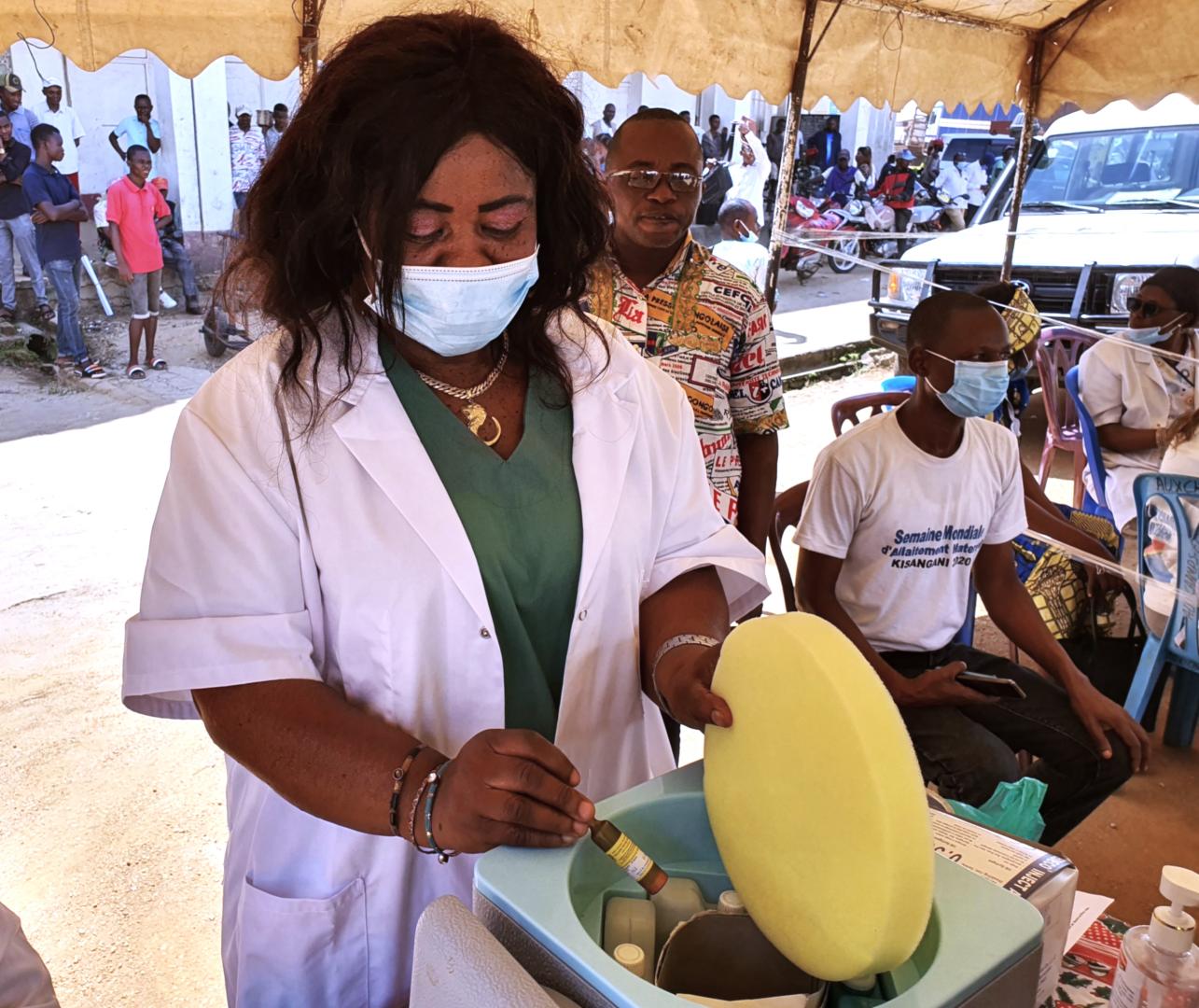 Une vaccinatrice tient un flacon de vaccin contre la fièvre jaune, lors d’une campagne menée en République démocratique du Congo. Crédit photo : OMS / Eugène Kabambi