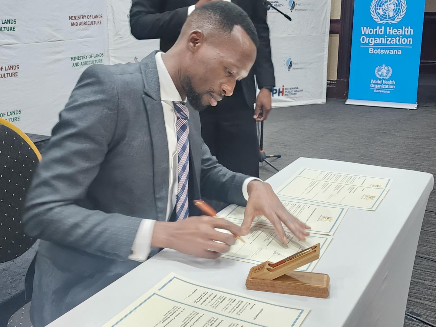 Honorable Acting Minister of Health, Mr Lawrence Ookeditse, signing the commitment for the implementation of the One Health National Strategy