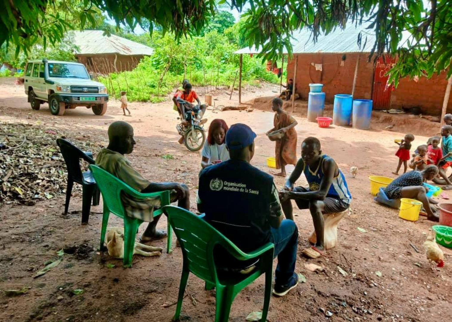 Profissional da OMS conversa com moradores de uma comunidade rural.