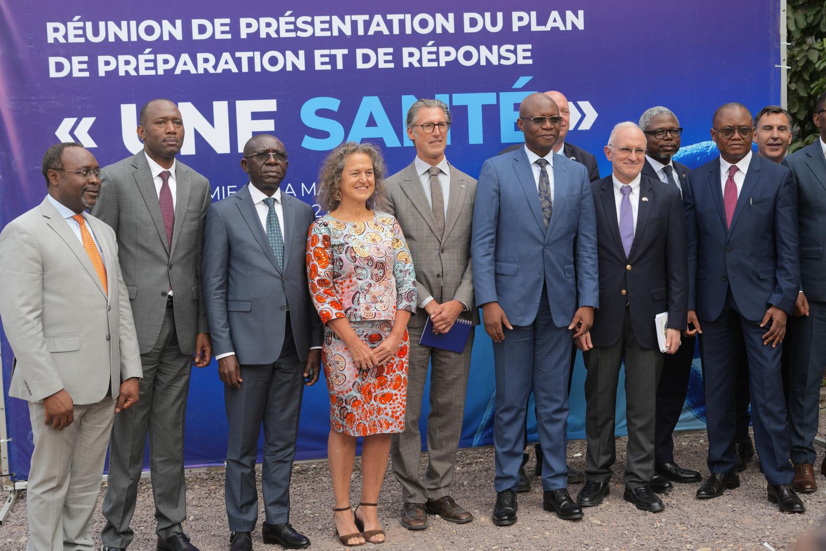 Photo de famille à l’issue du lancement à Kinshasa du Plan de deuxième génération de préparation et de riposte à l’épidémie d’Ebola, réunissant le ministre de la Santé publique, Dr Samuel Roger Kamba, la Dre Anne Ancia, Représentante par intérim de l’OMS, le Dr Hyppolite Kalambay, Directeur d’Africa CDC en RDC, ainsi que plusieurs personnalités et partenaires de haut niveau, dont des ambassadeurs.