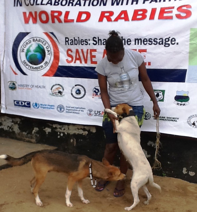 A dog owner her dogs to a vaccination site during the commemoration of World Rabies Day in New Kru Town