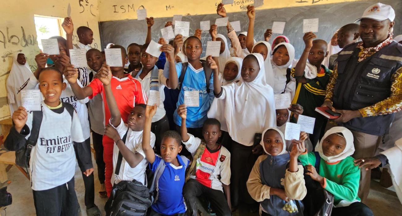 Des enfants exhibant leurs cartes de vaccination