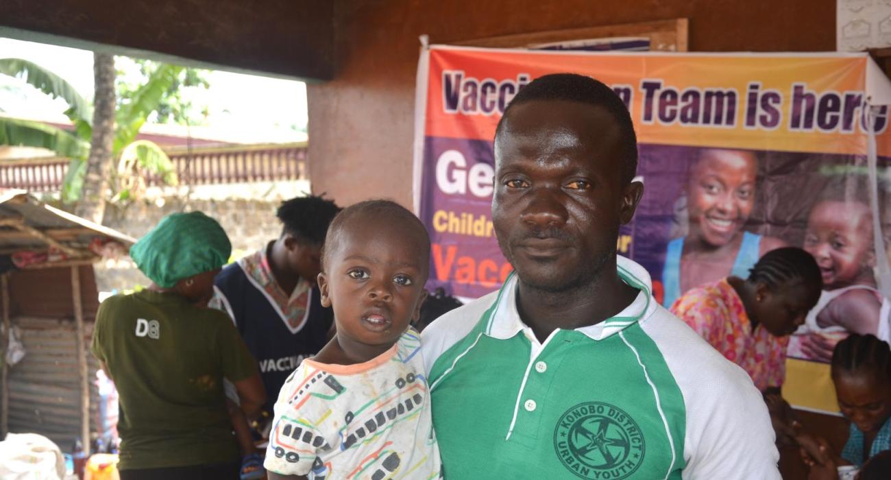 hedrick Barlee, with his one-year-old son Blessed Barlee, at the vaccination campaign