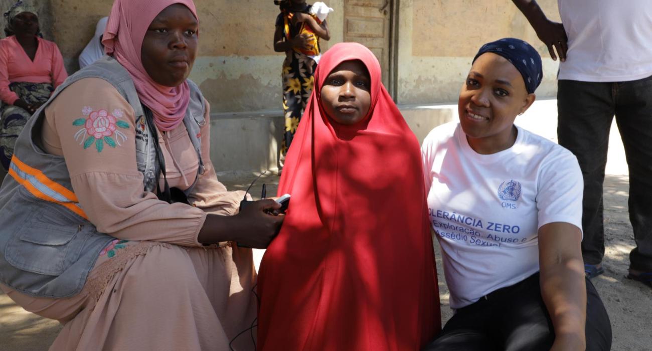 Vanessa Samuel in the center of the photo, a WHO employee is on her right, and a MISAU employee is on her left.