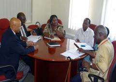 dr alemu in blue jacket in discussion with dr mbidde attended by who and uvri staff.