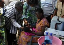 Baby Ernestina receiving Oral Polio Vaccine from the Minister of health