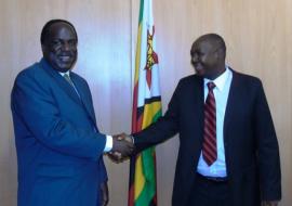 Dr David Okello and Mr Aldrin Musiiwa shaking hands