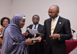 Mr Awute handing over WHO scholarship to one of the benefiting tutors