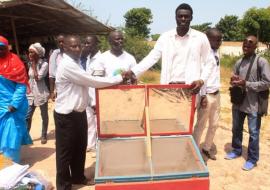 Deputy Director Health Promotion  handing-over locally produced solar cookers to the OIC of the psychiactric hospital