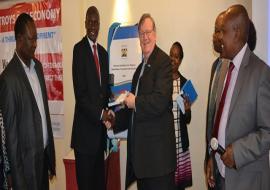 WR Kenya Dr Rudi Eggers receives a copy of the National guidelines for Tobacco Dependence Treatment & Cessation from Dr Patrick Amoth, MOH, while others look on