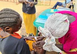 A health worker administers a polio vaccine to a child in Juba 