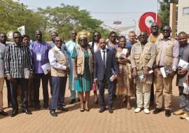 Une photo de famille de lauréats avec le Représentant de l’OMS au Burkina Faso, Dr Seydou Coulibaly, en chemise bleue à manche longueue