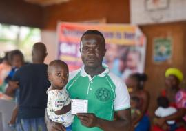 Shedrick Barlee, with his one-year-old son Blessed Barlee, at the vaccination campaign