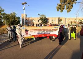 Les participants à la marche de santé tenant une banderole dans une rue de Maradi 