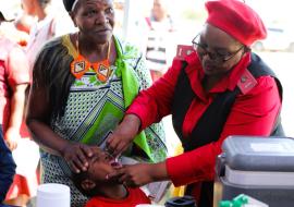 Health workers administering vaccines to children