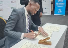 Honorable Acting Minister of Health, Mr Lawrence Ookeditse, signing the commitment for the implementation of the One Health National Strategy