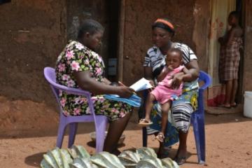 A community resource person assessing a sick child in Abia