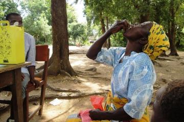A woman taking a swig of the Oral Cholera Vaccine in Nsanje