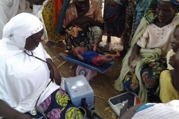 18-day old baby weighed before receiving vaccines