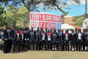 Some of the blood donors in front of the banner