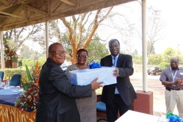 Dr Okello presenting farewell gift to Dr and Mrs Charimari
