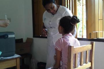 EPI nurse counsels a primary six student before administration of the vaccine at the school.jpg