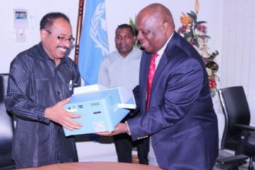 The WHO Representative, Dr. Rufaro Chatora handing over an ELISA Reader to the Minister for Health and Social Welfare, Hon. Dr Seif Rashid.